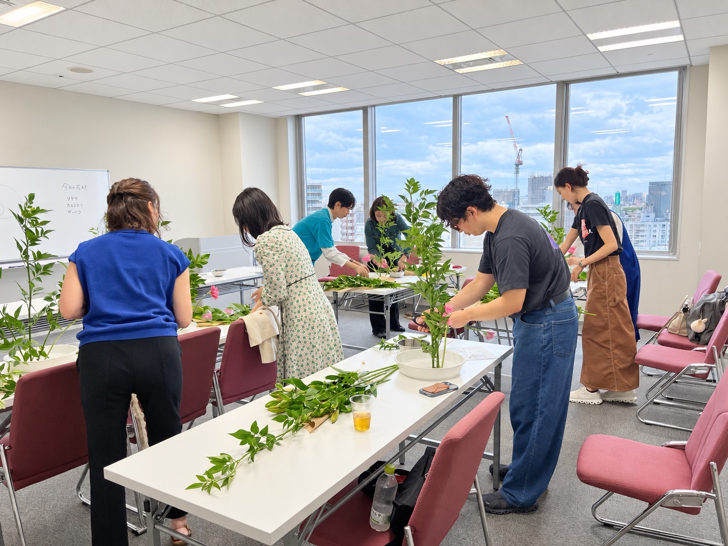 明るい会場で参加者のみなさんがいけばなを楽しんでいる様子