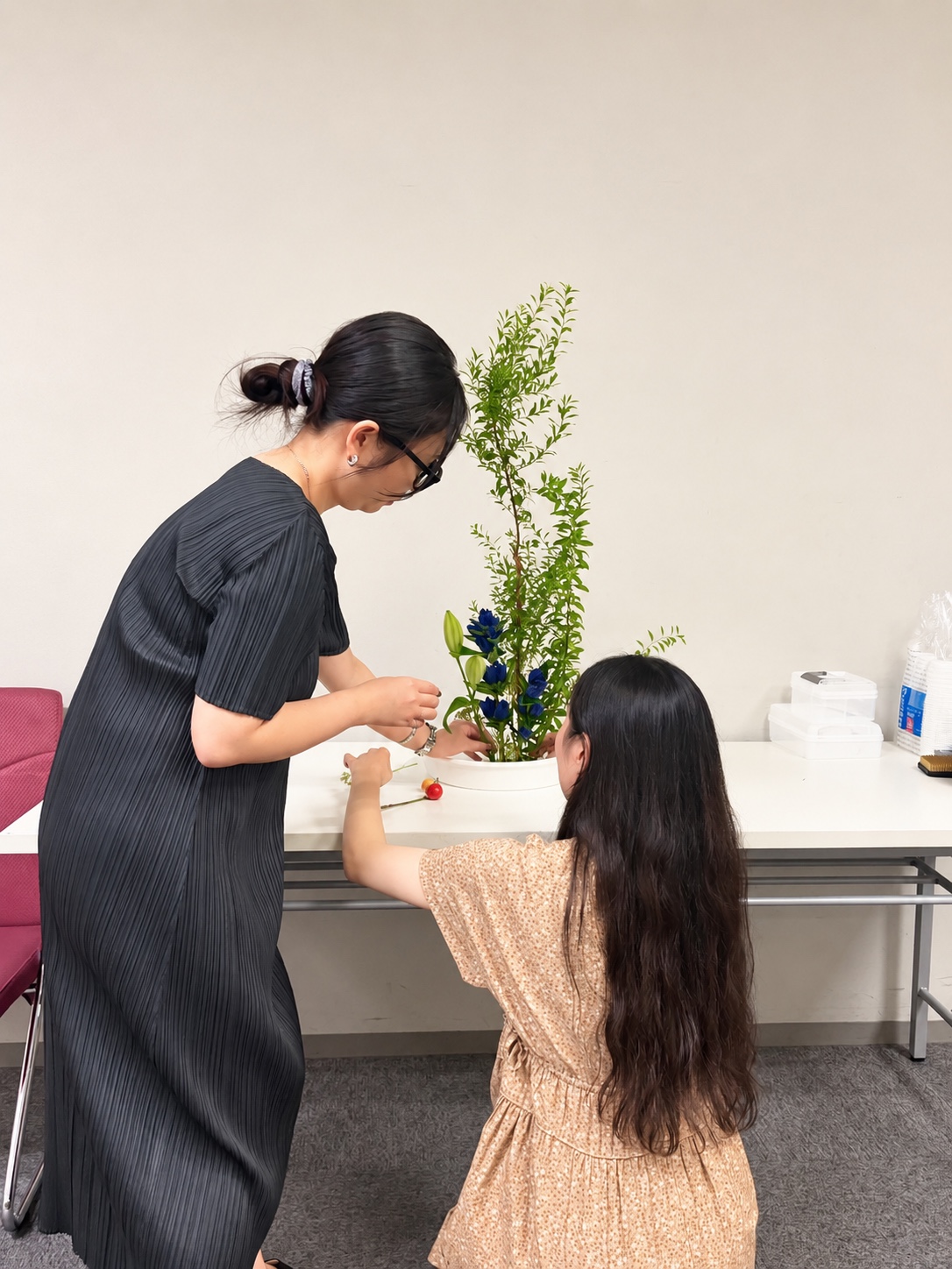 講師が参加者に寄り添っていけばなを伝えている様子